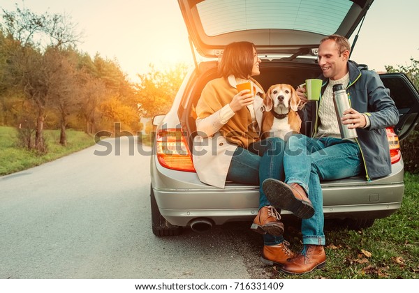 Tea party in car truck - loving couple with dog\
sits in car truck