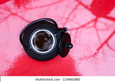 Tea pot in front of red background