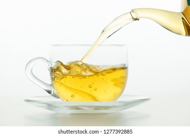 Tea pouring into tea cup on white background