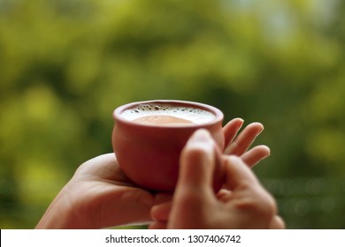 Tea served in a natural clay cup with background