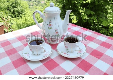 tea service in nostalgic teapots and cups, natural background