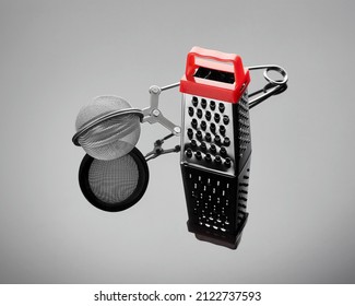 Tea strainer and grater for vegetables on gray glossy background