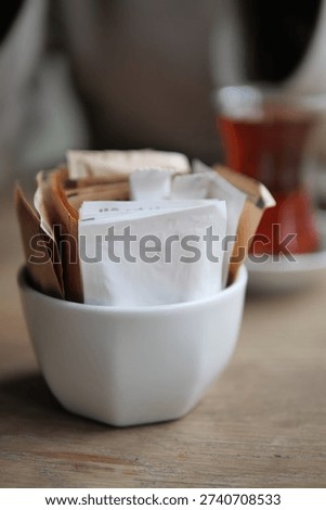 Tea and sugar packets on a table in a cozy setting