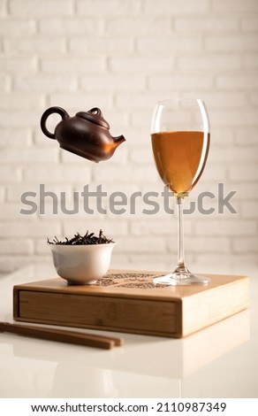 tea table with appliances and a wine glass in which tea is brewed