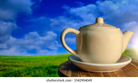Tea and teapot on table, natural background blurred blue sky and meadow - Shutterstock ID 1542904049