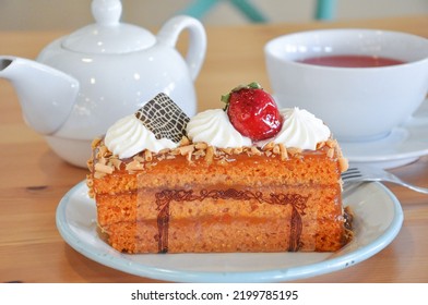 Tea Time With Carrot Cake And A Cup Of Tea. Fancy Cake Set Up On Wood Table Background.