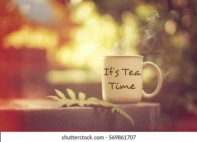It's tea time concept: having fun while enjoying a hot cup of coffee outdoors - Shutterstock ID 569861707