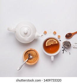 Tea Time Creative Composition. Cup, Teapot And Sugar On The White Background, Top View