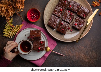 Tea Time: Woman Holding A Cup Of Hot Tea And Chocolate Cake With Cranberries. Autumn Background. Copy Space.