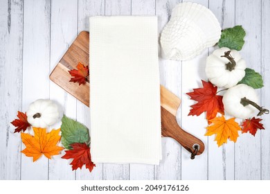 Tea Towel Dish Cloth Product Mockup. Thanksgiving Farmhouse Theme With Turkey, White Pumpkins And Autumn Fall Leaves, On A White Wood Background. Negative Copy Space.