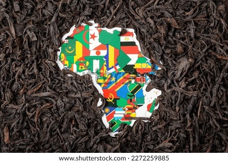 Tea trade in African continent. Map of African countries surrounded by dried black tea leaves, close up