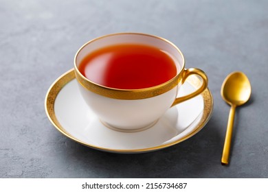 Tea In White Cup With Gold Rim. Grey Background. Close Up.