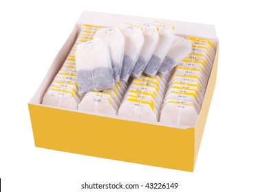 teabags in yellow paper box lying isolated on white background.