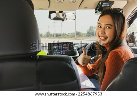 Teach driving : Beautiful young asian beginner preparing to learn driving taught by expert instructors from driving school to drive on roads safely thumbs up to great teaching and driving lessons. 