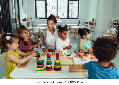 Teacher and adorable children being creative with colorful toys - Powered by Shutterstock