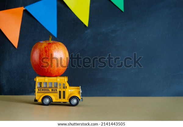 Teacher\
Appreciation Week school banner. Black schoolboard with colorful\
garland, red apple on yellow toy bus and place for text. End of\
school year or first day of school concept.\
