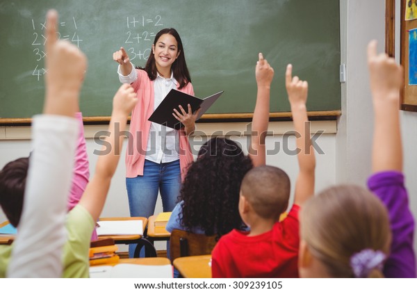 Teacher asking her students a question at the\
elementary school