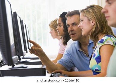 Teacher Assisting College Student In A Computer Lab