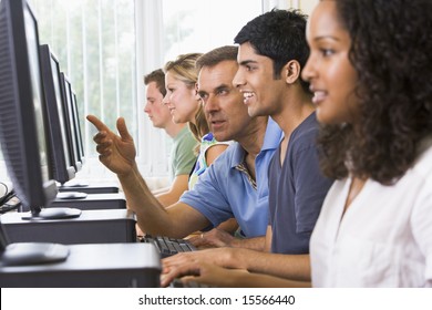 Teacher Assisting College Student In A Computer Lab