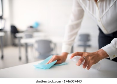 Teacher back at school after covid-19 quarantine and lockdown, disinfecting desks. - Powered by Shutterstock