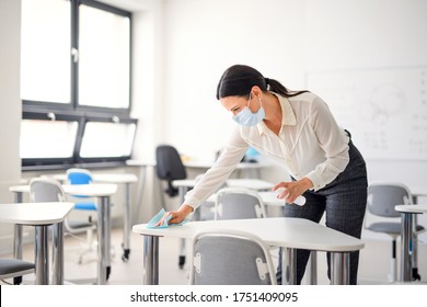 Teacher back at school after covid-19 quarantine and lockdown, disinfecting desks. - Powered by Shutterstock