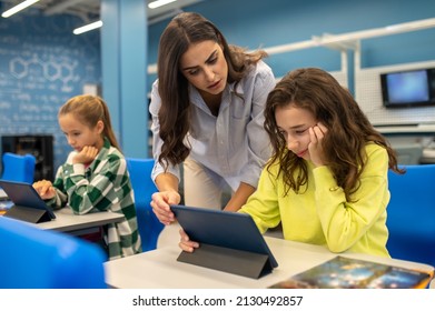 Teacher Bent Over Thinking Girl With Tablet