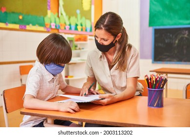 Teacher And Child With Mask Because Of Covid-19 Do Homework Together