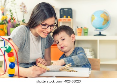 Teacher And Child Playing And Learning At Classroom