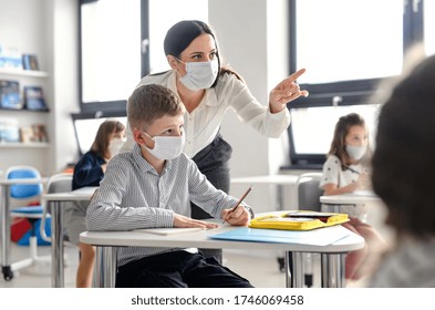 Profesora y niños con mascarilla en la escuela luego de la cuarentena y bloqueo covid-19.