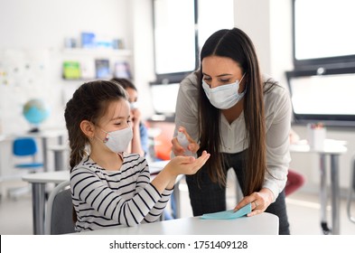 Teacher And Children With Face Mask Back At School, Disinfecting Hands.