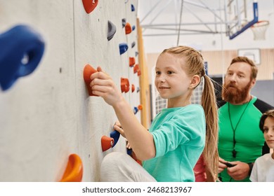 teacher and children, gathered around a colorful climbing wall, engaging in climbing and receiving instructions - Powered by Shutterstock