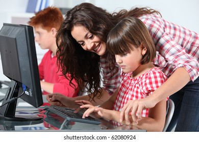 Teacher and children learning to use computer