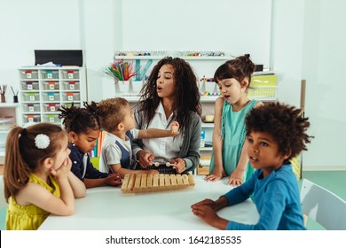 Teacher with children playing at kindergarten - Powered by Shutterstock