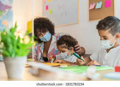 Teacher With Children Wearing Face Mask In Preschool Classroom During Corona Virus Pandemic - Healthcare And Education Concept