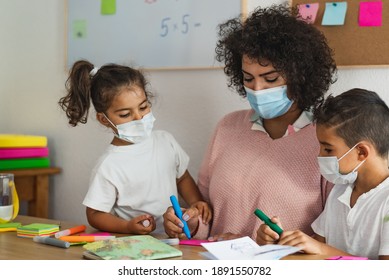 Teacher With Children Wearing Face Mask In Preschool Classroom During Corona Virus Pandemic - Healthcare And Education Concept