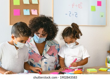 Teacher With Children Wearing Face Mask In Preschool Classroom During Corona Virus Pandemic - Healthcare And Education Concept