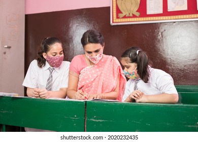 Teacher With Children Wearing Face Mask In Preschool Classroom During Corona Virus Pandemic