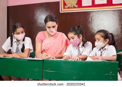 Teacher With Children Wearing Face Mask In Preschool Classroom During Corona Virus Pandemic