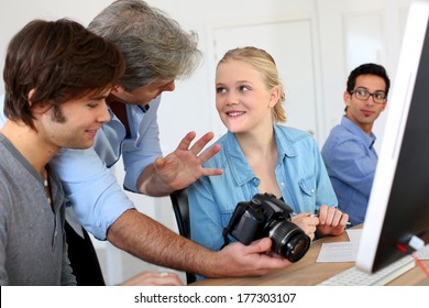 Teacher In Class Of Photography With Students