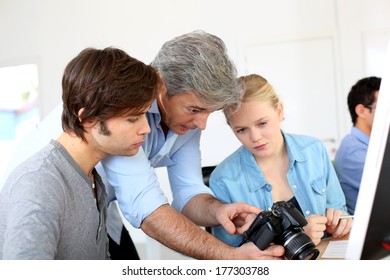 Teacher In Class Of Photography With Students