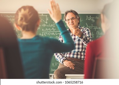 Teacher In The Classroom Hands Up Students