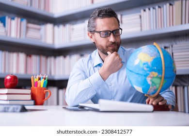 Teacher in classroom. Knowledge and education with handsome teacher. Teacher with book in classroom. Man on lesson in class. Teachers from university exam. College teacher. Teaching and learning.