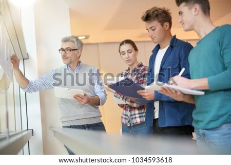 Teacher in classroom teaching economics to young people
