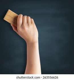 Teacher cleaning the chalkboard with a chalk duster