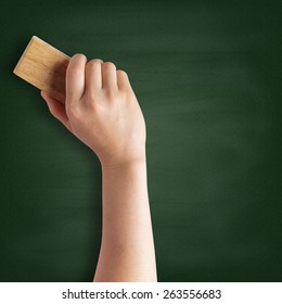 Teacher cleaning the chalkboard with a chalk duster - Shutterstock ID 263556683