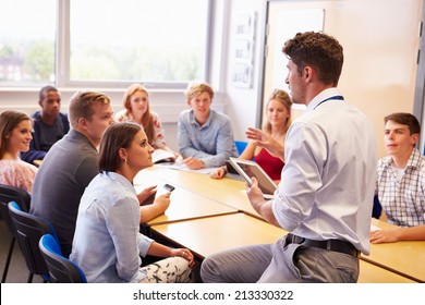 Teacher With College Students Giving Lesson In Classroom