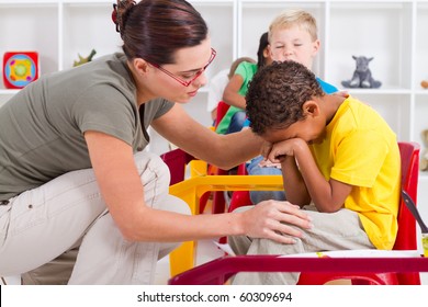 Teacher Comforting Crying Preschool Boy