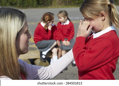 Teacher Comforting Victim Of Bullying In Playground - Powered by Shutterstock