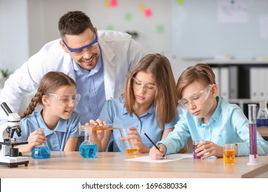 Teacher Conducting Chemistry Lesson In Classroom