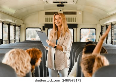 Teacher counting marking attendance of group of kids pupils schoolchildren at school bus before lessons. Welcome back to school after summer holidays! New educational year semester. - Powered by Shutterstock